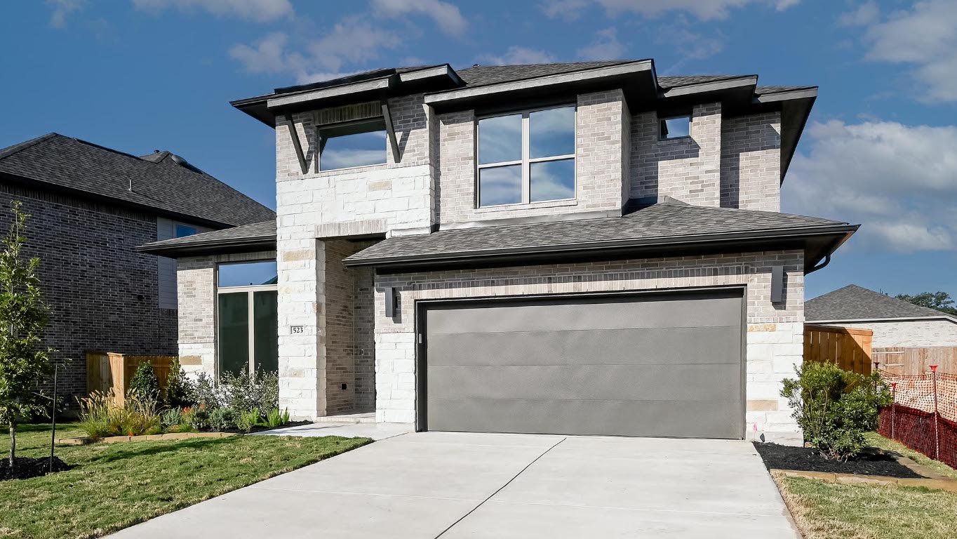 523 Prickly Poppy Loop Kyle, TX 78640 - Photo 3 of 40 Modern home with stone siding, concrete driveway, and a shingled roof