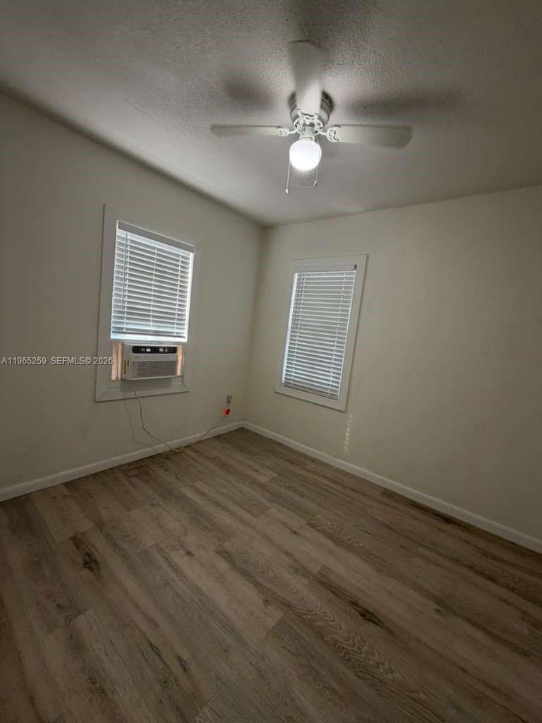 140 Northwest 13th Street, Unit 154 Miami, FL 33136 - Photo 17 of 18 an empty room with wooden floor fan and windows