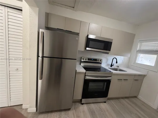 a kitchen with stainless steel appliances a refrigerator sink and microwave