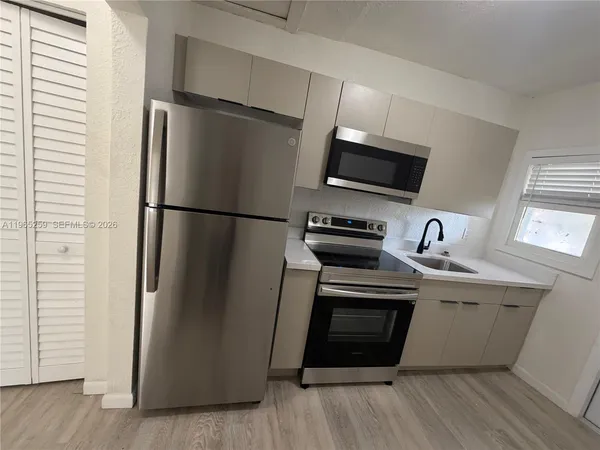 a kitchen with stainless steel appliances a refrigerator sink and microwave