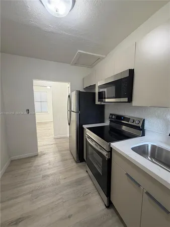 a kitchen with granite countertop a stove and a refrigerator