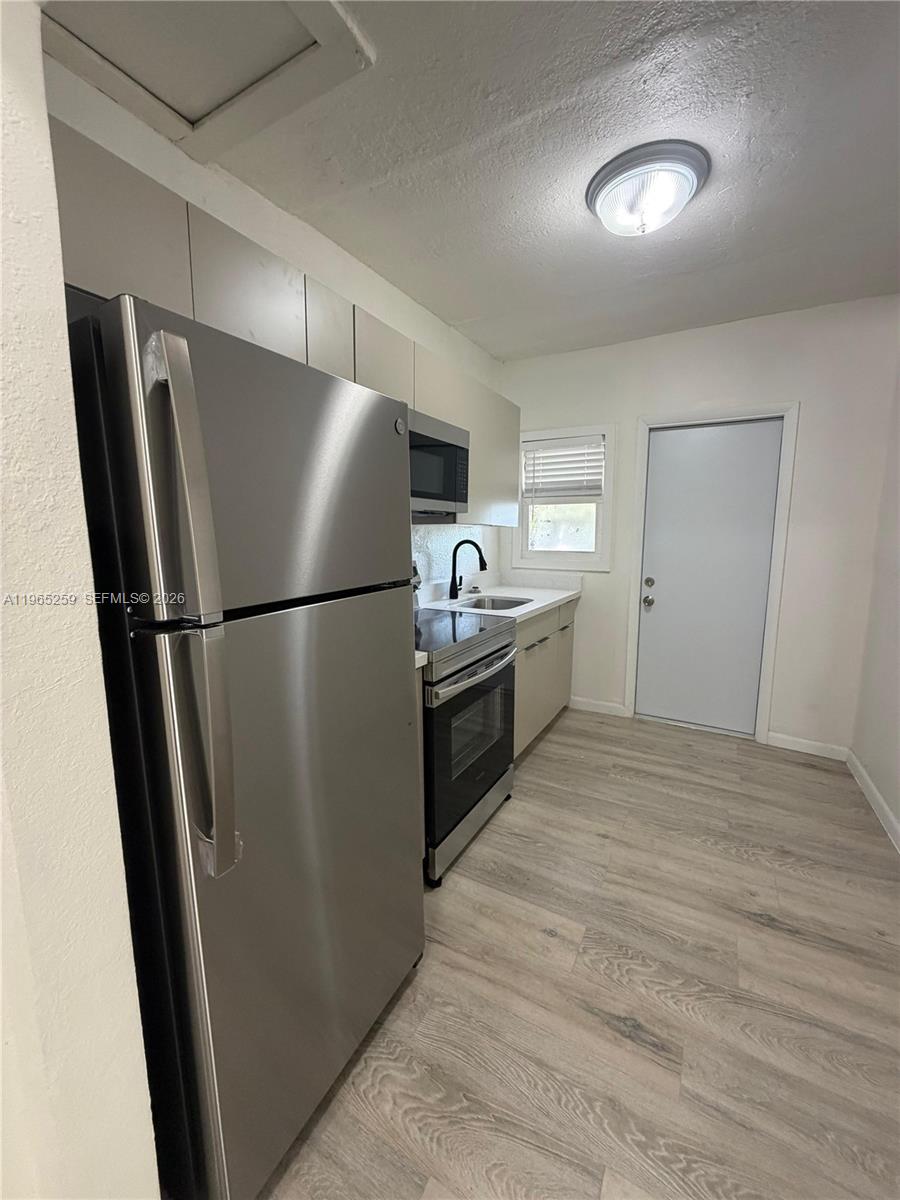 140 Northwest 13th Street, Unit 154 Miami, FL 33136 - Photo 9 of 18 a kitchen with stainless steel appliances a refrigerator a sink and a stove