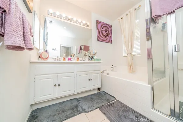 a bathroom with a sink a mirror a vanity and bathtub