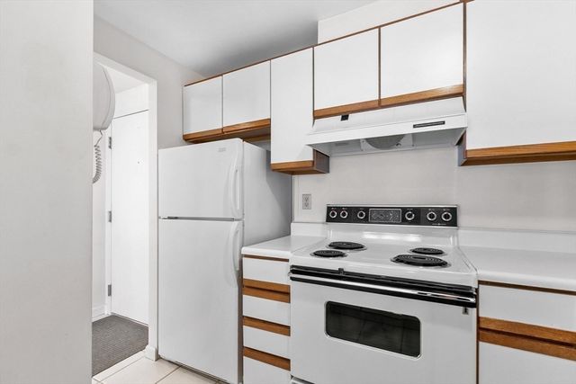 a kitchen with a white stove and white cabinets