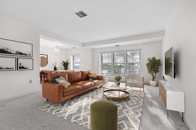 a living room with furniture flat screen tv and a large window