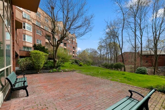 a view of a big building with big yard and large trees