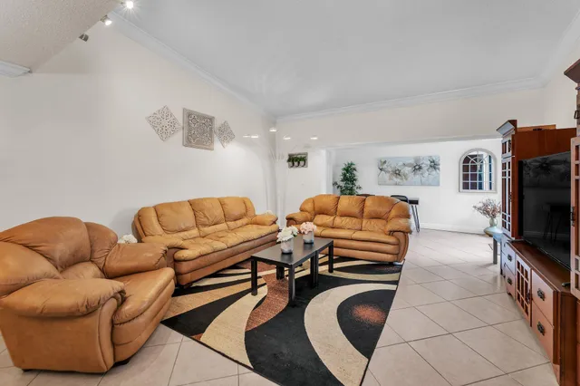a living room with furniture a flat screen tv and kitchen view