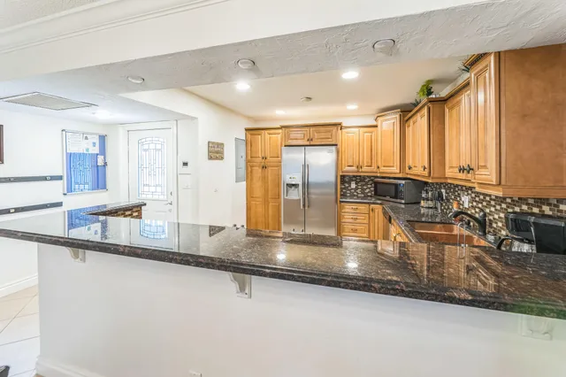 a kitchen with kitchen island granite countertop a sink and a counter top space