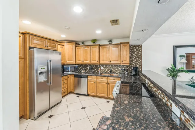 a large white kitchen with a large window and stainless steel appliances