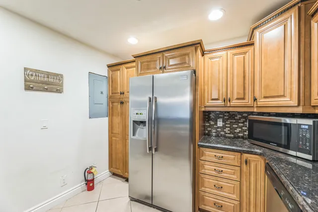 a kitchen with stainless steel appliances granite countertop a refrigerator and a stove top oven