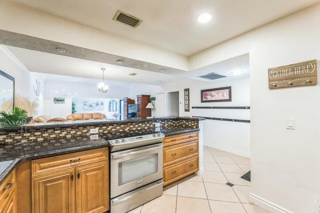 a kitchen with stainless steel appliances granite countertop a stove a sink and a refrigerator