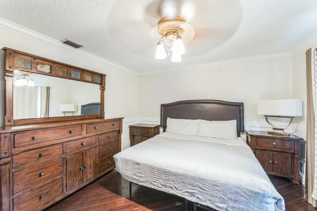 a bedroom with a large bed and a large mirror on dresser