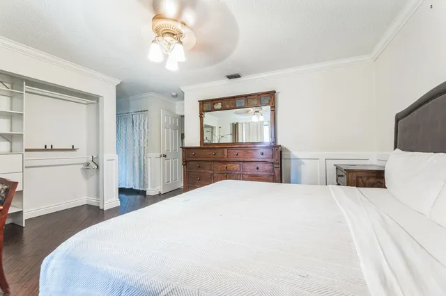 a large bedroom with a bed and a flat screen tv