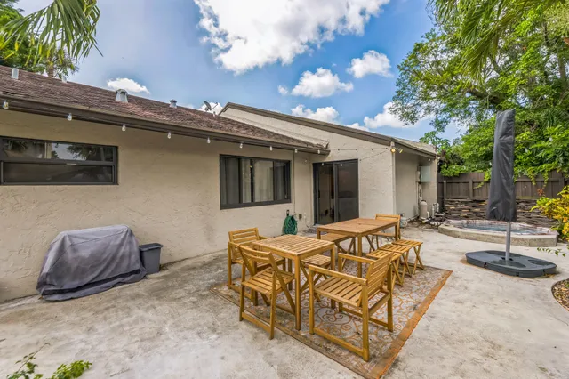 a view of a patio with table and chairs with wooden floor and fence