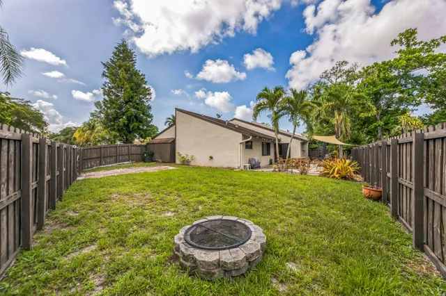 a backyard of a house with table and chairs