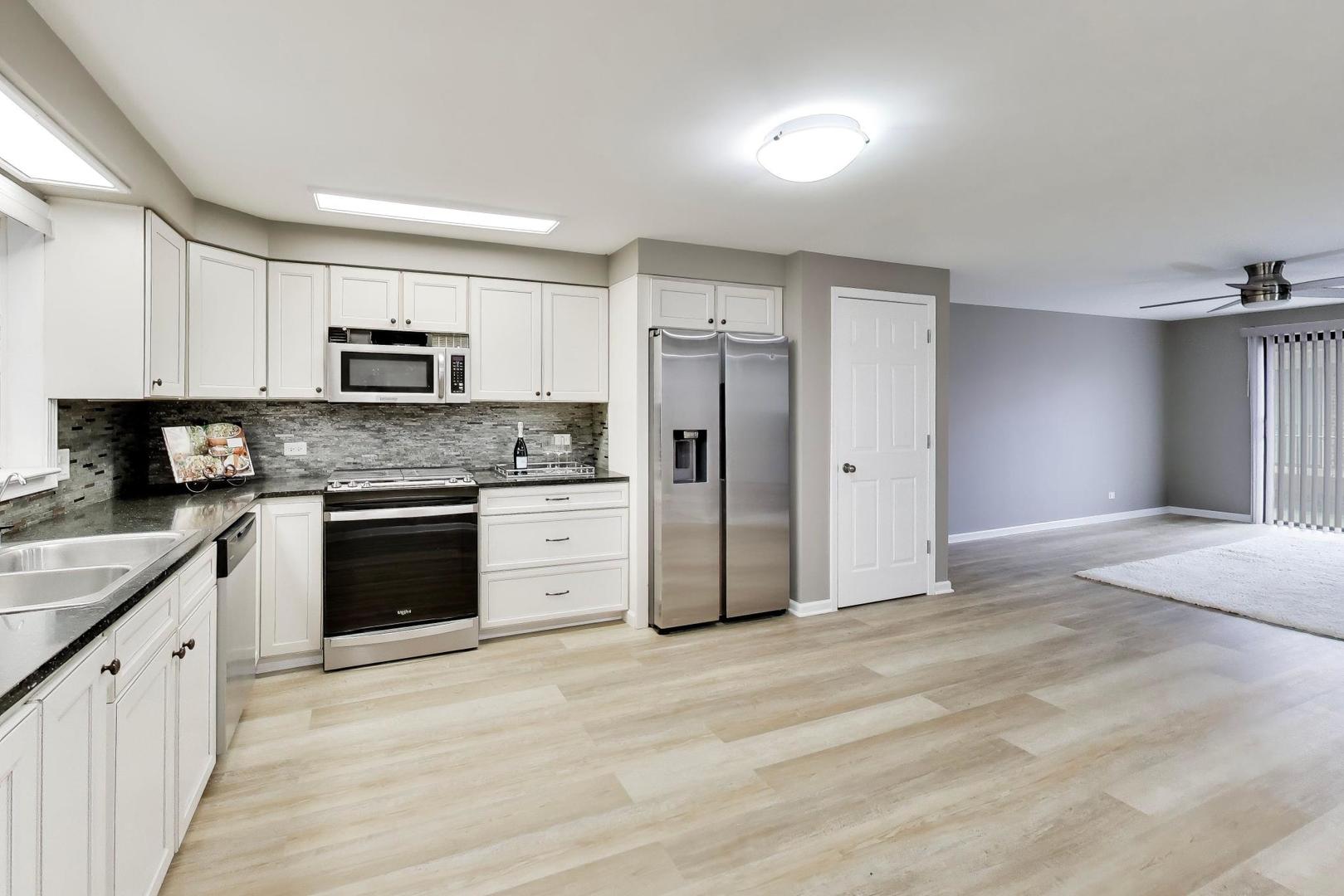 22 North Pistakee Lake Road, Unit 3E Fox Lake, IL 60020 - Photo 3 of 27 a kitchen with kitchen island granite countertop a stove a sink and a refrigerator