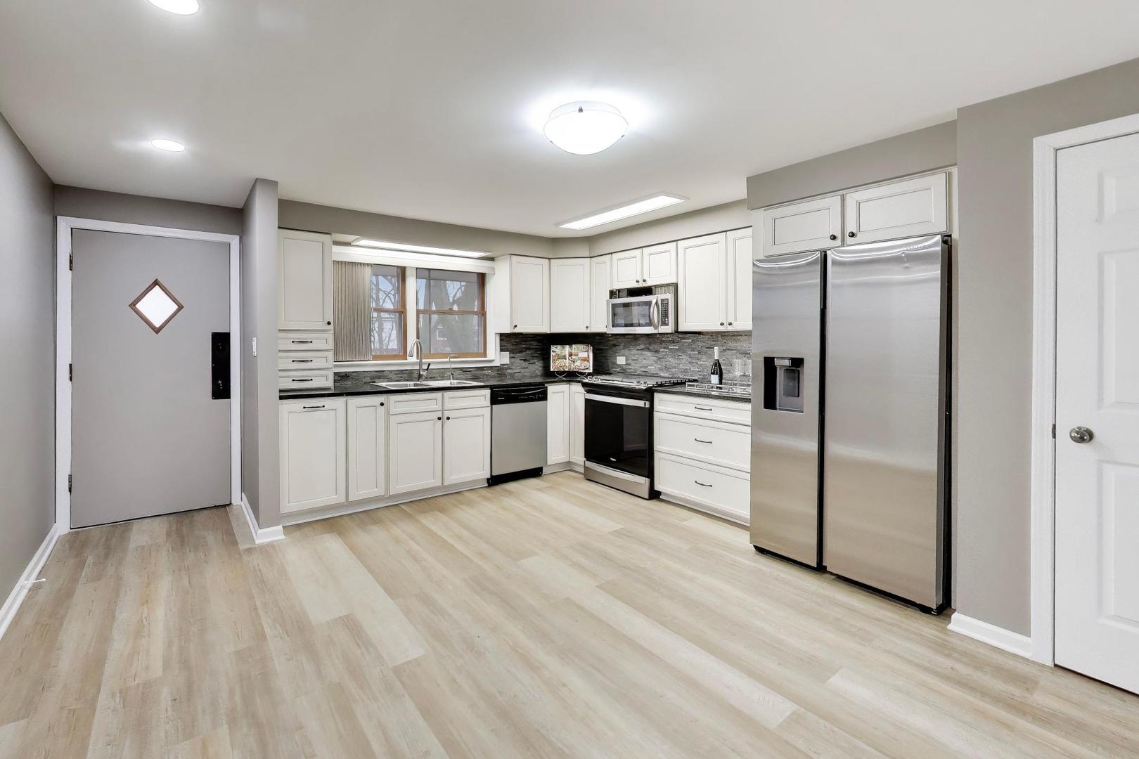 22 North Pistakee Lake Road, Unit 3E Fox Lake, IL 60020 - Photo 5 of 27 a kitchen with white cabinets and stainless steel appliances