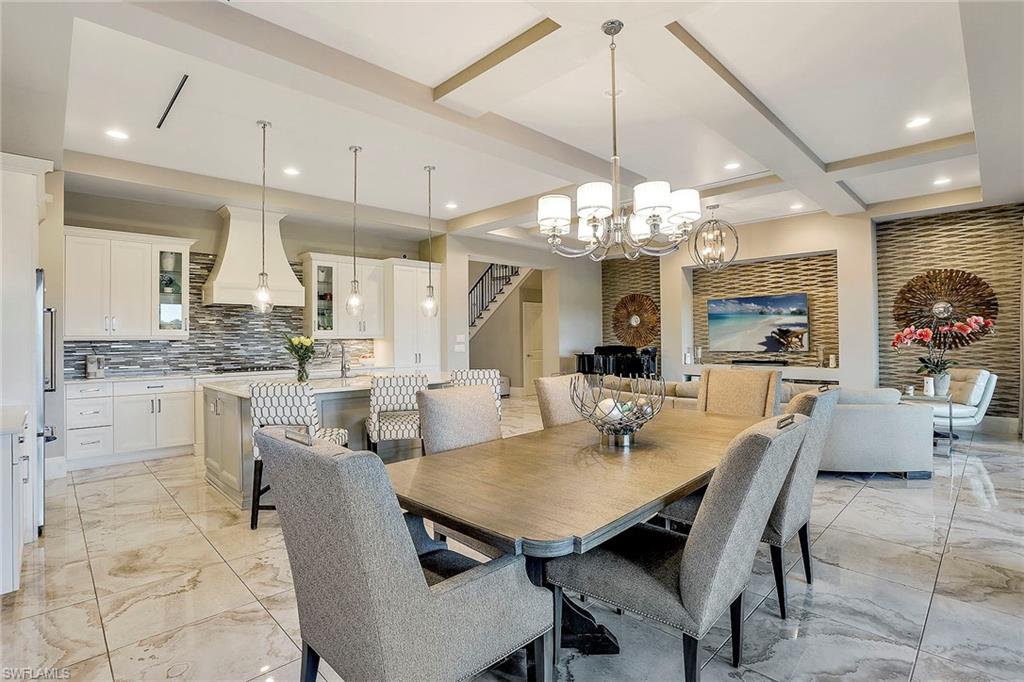 16776 Brightling Way Naples, FL 34110 - Photo 13 of 35 a dining room filled chandelier and kitchen view