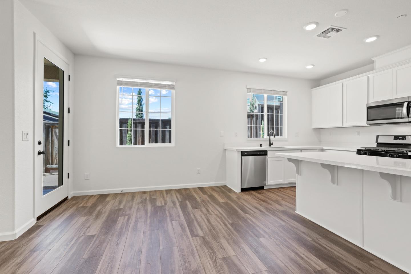 4503 Gray Lodge Loop Rocklin, CA 95677 - Photo 10 of 35 a kitchen with a wooden floors and white cabinets