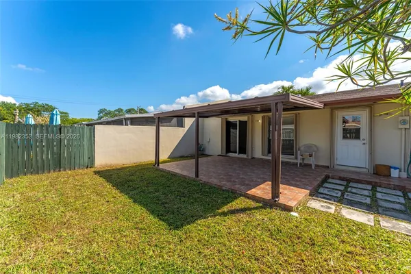 a view of a house with backyard and sitting area