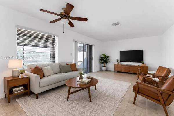 a view of a big room with a chandelier fan and refrigerator