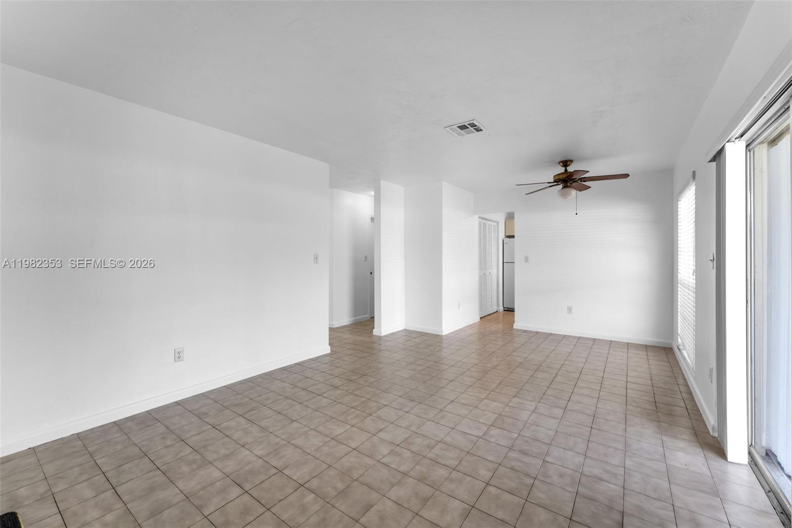 12983 Southwest 18th Terrace Miami, FL 33175 - Photo 7 of 25 a view of a big room with a chandelier fan and refrigerator