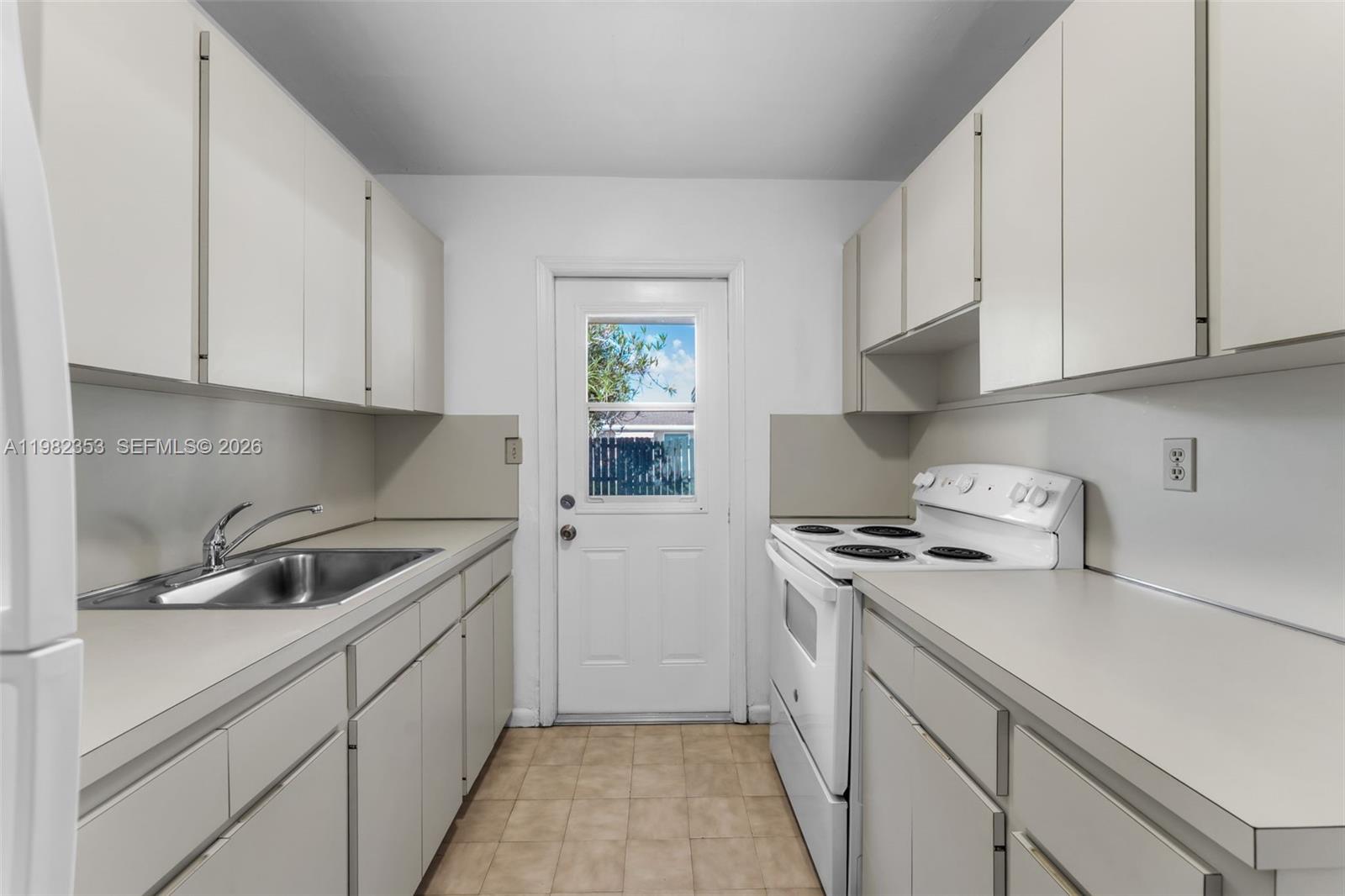 12983 Southwest 18th Terrace Miami, FL 33175 - Photo 8 of 25 a kitchen with sink a stove and cabinets
