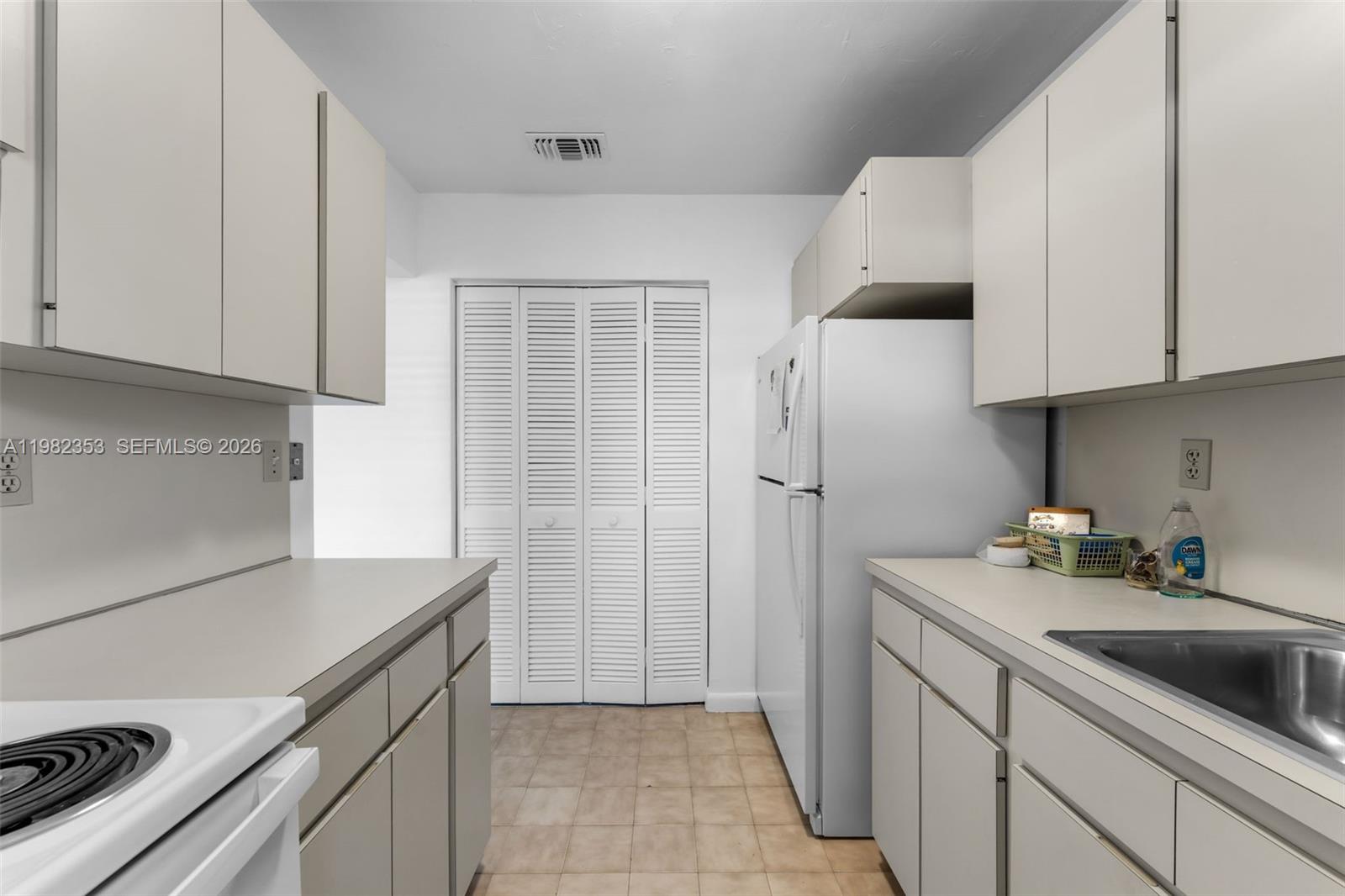 12983 Southwest 18th Terrace Miami, FL 33175 - Photo 9 of 25 a kitchen with a sink a refrigerator and cabinets