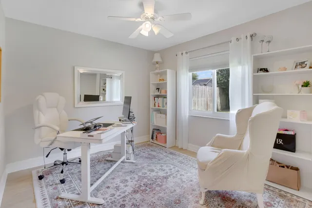 a living room with furniture a flat screen tv and a window