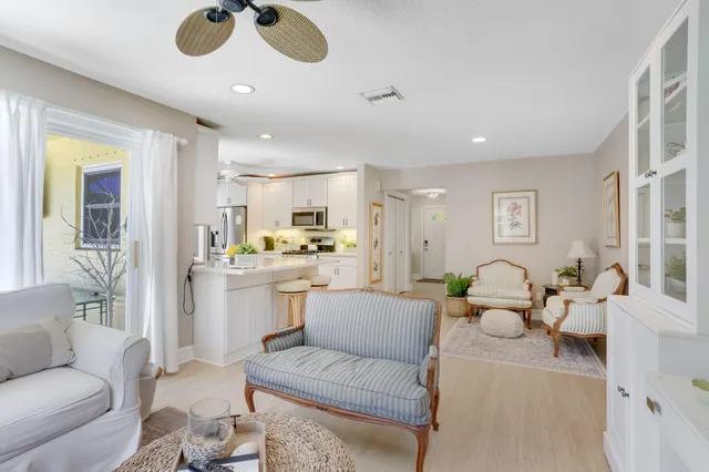 a living room with furniture kitchen view and a chandelier