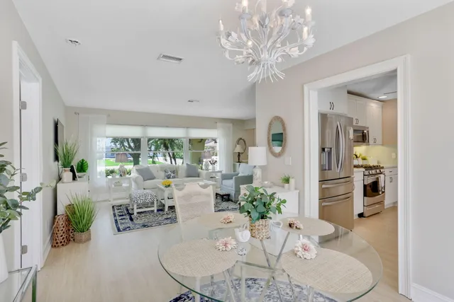 a living room with furniture a chandelier and a dining room