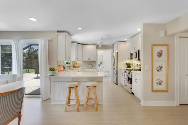 a kitchen with stainless steel appliances kitchen island granite countertop a refrigerator and a stove top oven