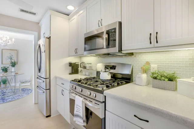 a kitchen with stainless steel appliances a stove a microwave and cabinets