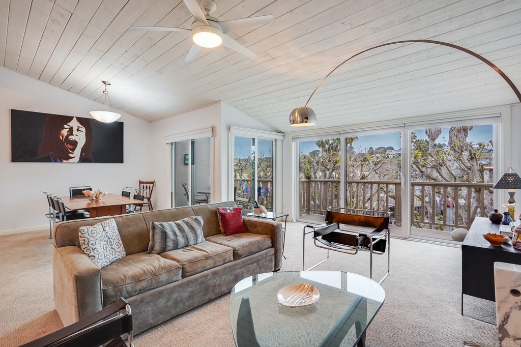 a living room with furniture a flat screen tv and a large window