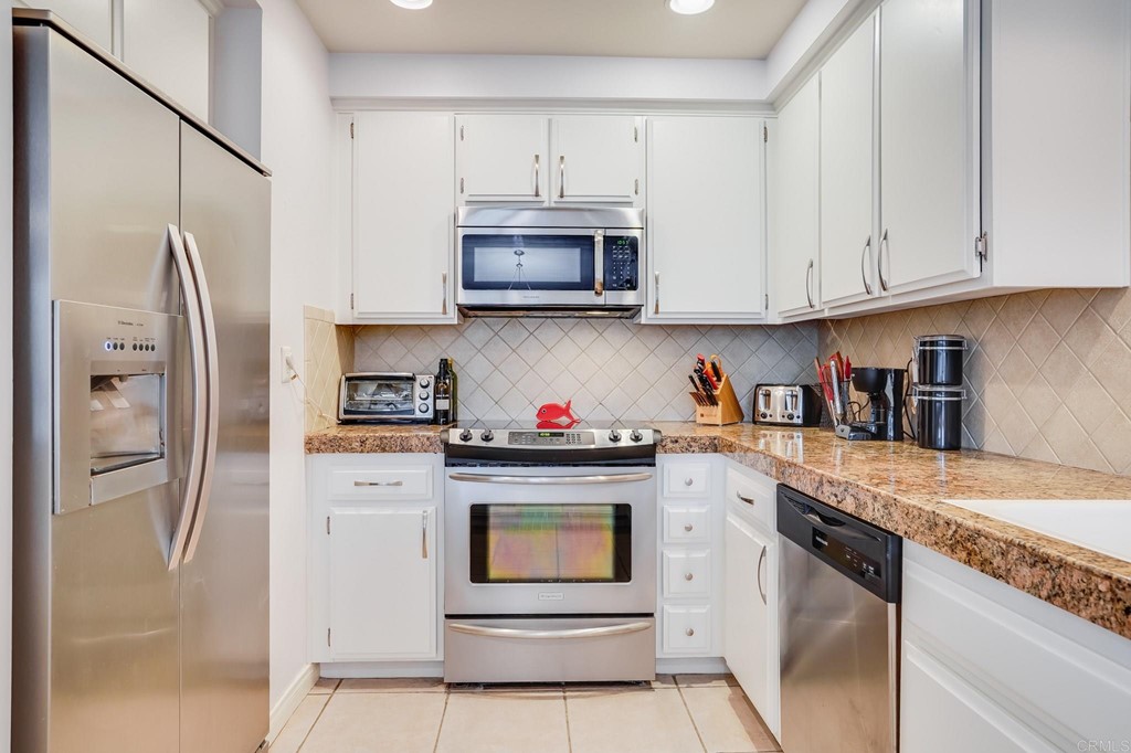 573 South Sierra Avenue, Unit 8 Solana Beach, CA 92075 - Photo 11 of 54 a kitchen with stainless steel appliances granite countertop a refrigerator sink and cabinets