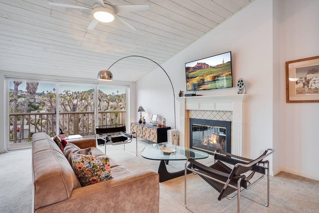 573 South Sierra Avenue, Unit 8 Solana Beach, CA 92075 - Photo 6 of 54 a living room with furniture a fireplace and a floor to ceiling window