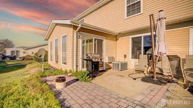a view of a patio with table and chairs near a barbeque