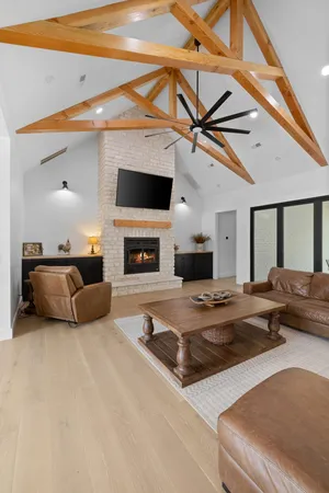 a living room with furniture a large window and a fireplace