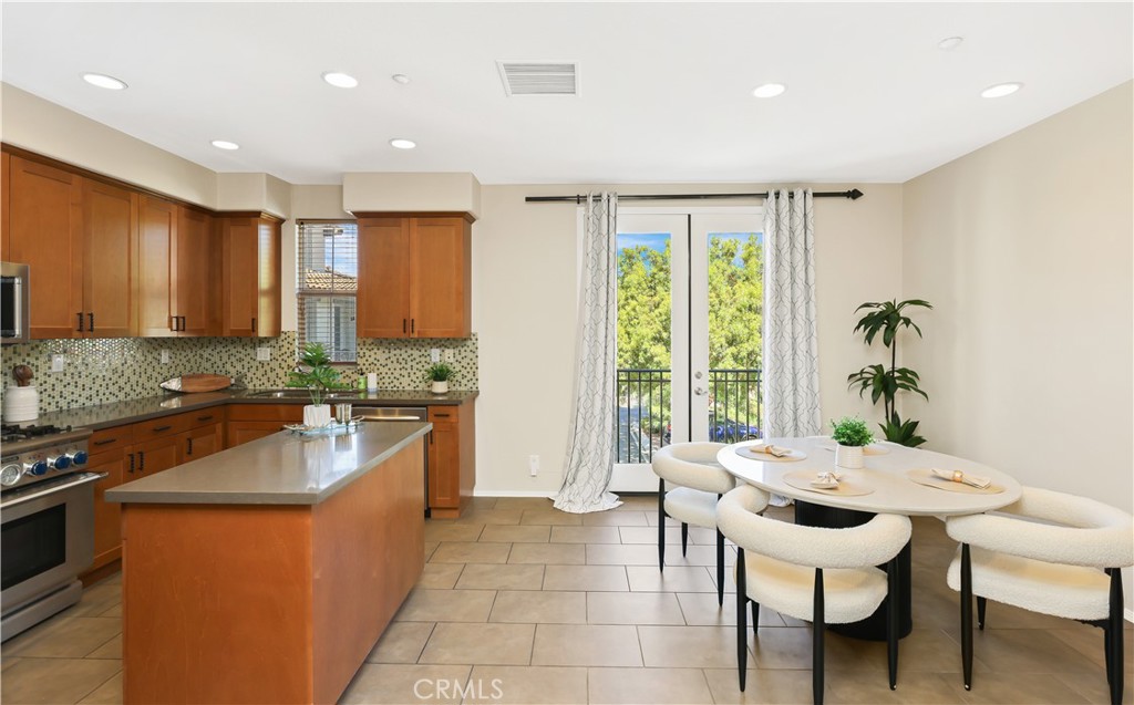 23 Crosspointe Irvine, CA 92618 - Photo 12 of 47 a kitchen with a table chairs stove and kitchen island