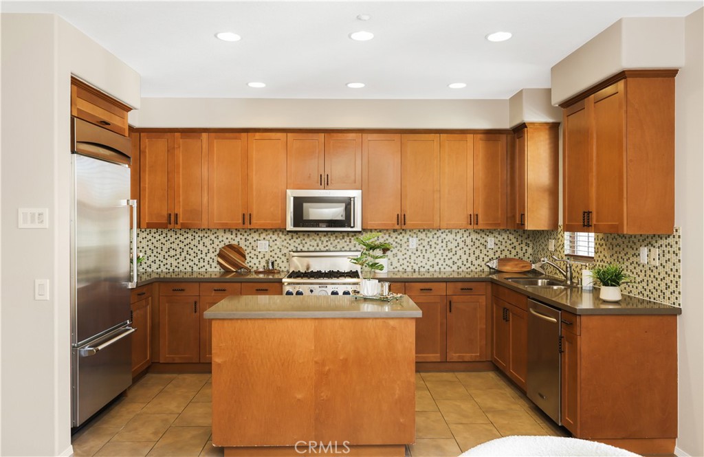 23 Crosspointe Irvine, CA 92618 - Photo 14 of 47 a kitchen with stainless steel appliances granite countertop a stove a sink dishwasher and a refrigerator