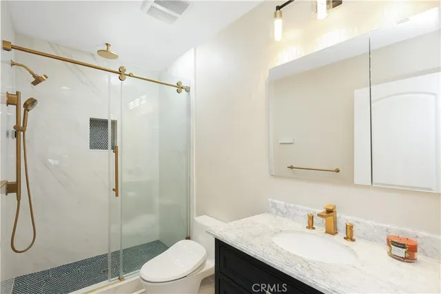 a bathroom with a granite countertop sink toilet and shower