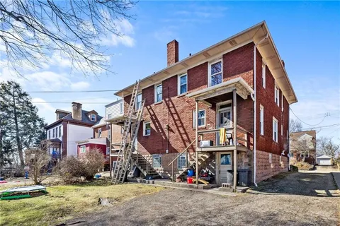 an aerial view of a house with garden space and mountains