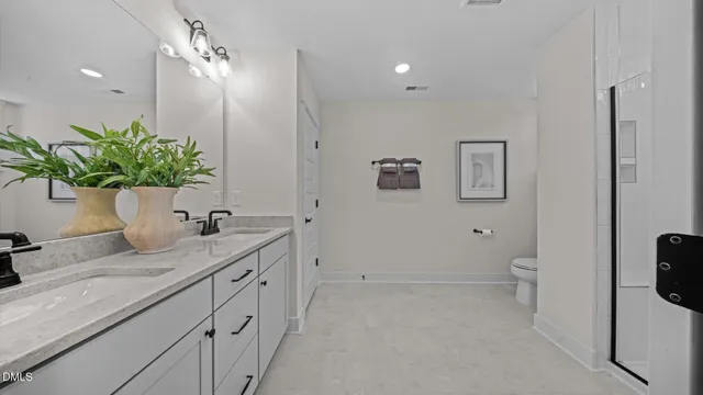 a en suite spacious bathroom with double sink and a mirror