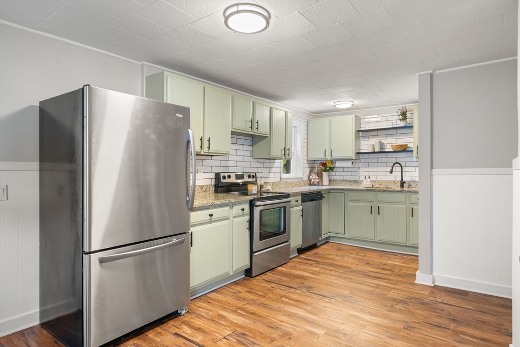56 Ruggles Street Franklin, MA 02038 - Photo 11 of 42 a kitchen with a refrigerator a sink and white cabinets