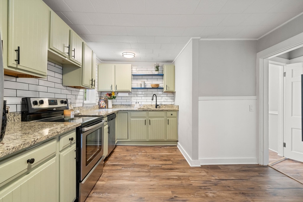 56 Ruggles Street Franklin, MA 02038 - Photo 12 of 42 a kitchen with stainless steel appliances granite countertop a stove top oven a sink and dishwasher with white cabinets