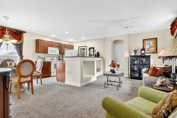 a living room with furniture kitchen view and a flat screen tv