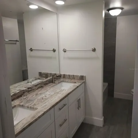 a bathroom with a granite countertop sink and a mirror