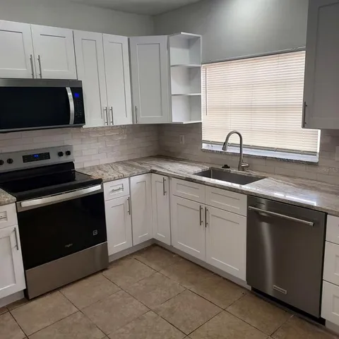 a kitchen with a sink and a stove top oven