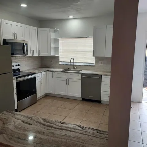 a kitchen with stainless steel appliances granite countertop a sink and stove top oven