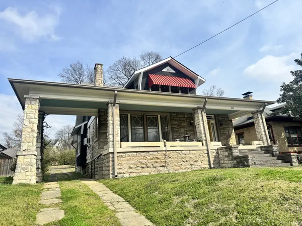 a view of a house with large windows and a small yard